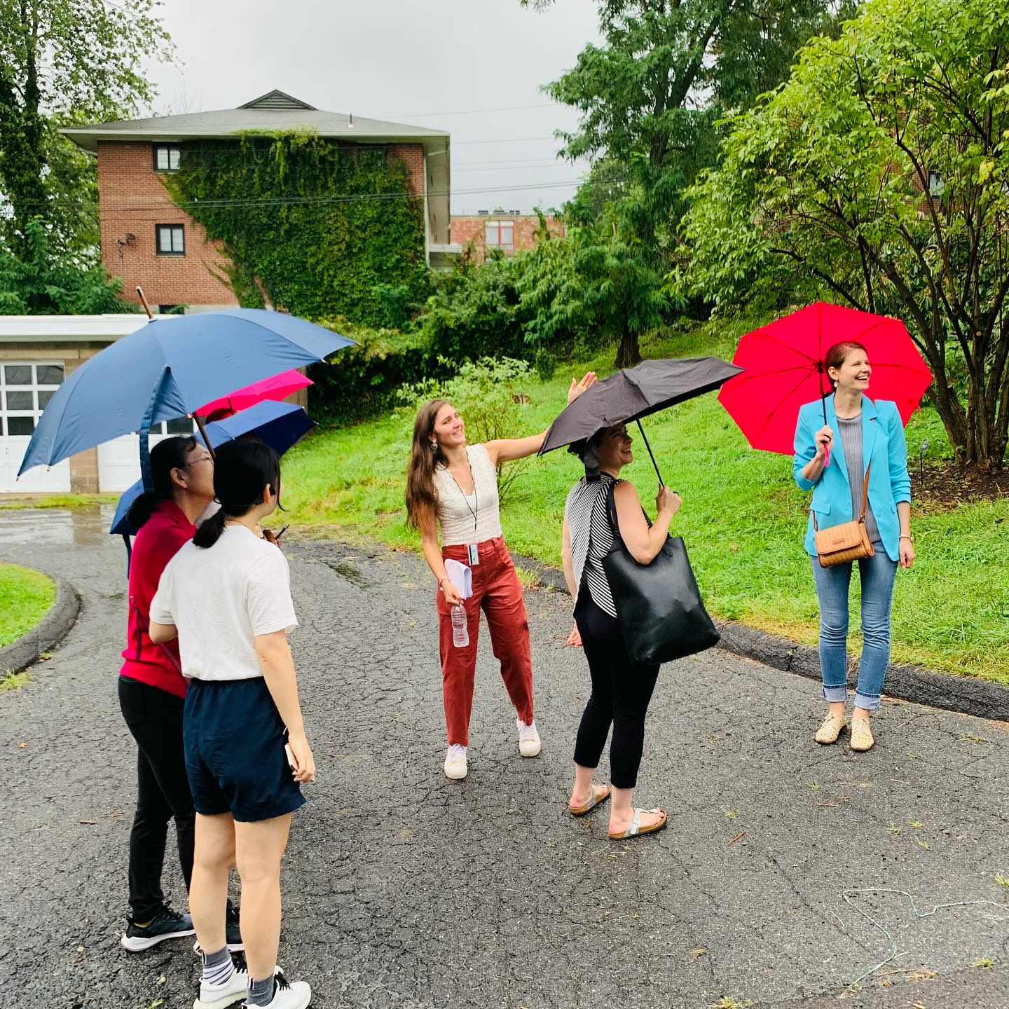 Postdocs outside in the rain holding umbrellas