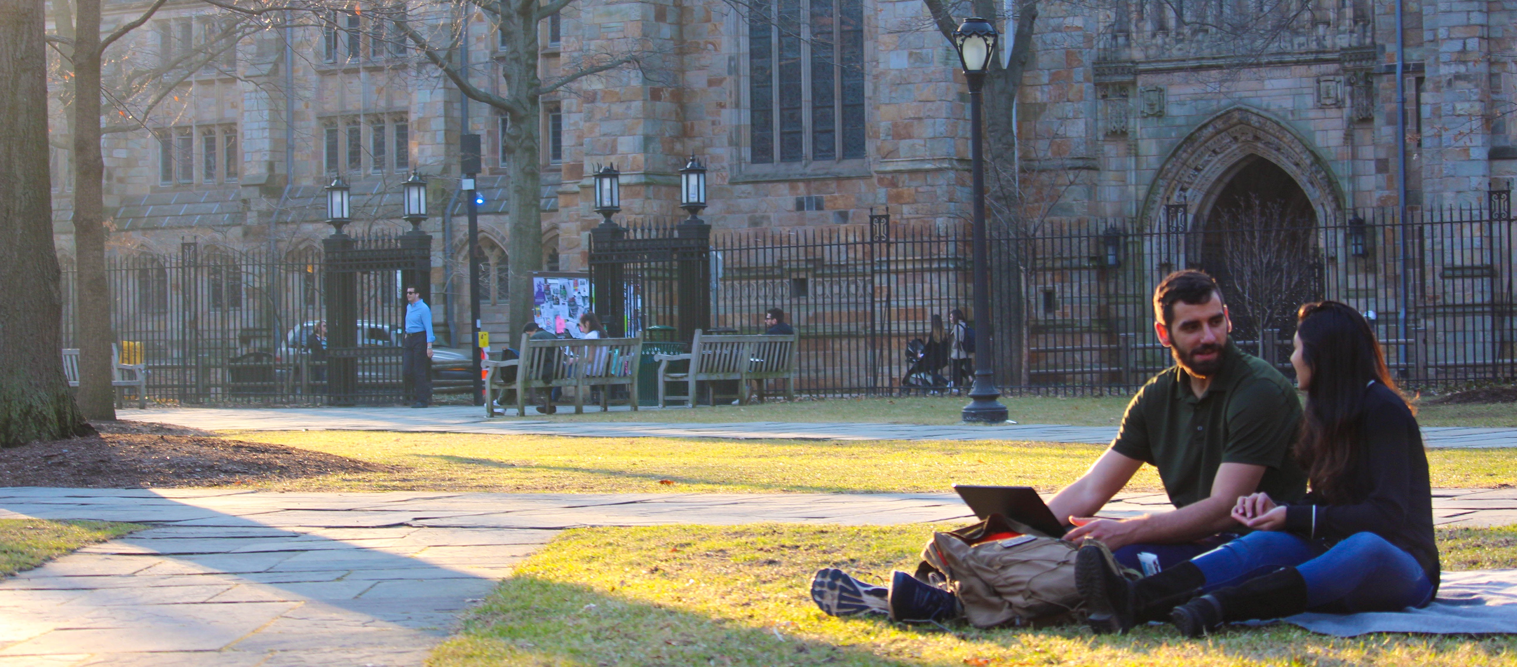 Two people sitting on grass talking