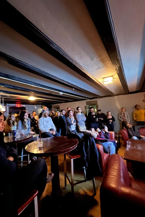 Postdocs at a pint of postdoc night listening to a speaker presenting their research 