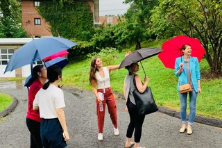 Postdocs outside in the rain holding umbrellas