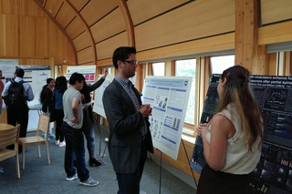 A person presenting their poster to another person