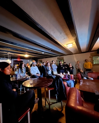 Postdocs at a pint of postdoc night listening to a speaker presenting their research 